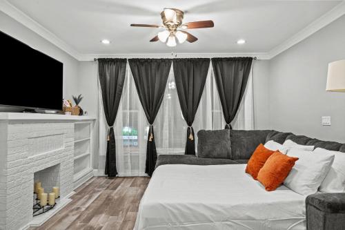 a living room with a couch and a ceiling fan at Little India Gem - Bollywood Retreat Near Markets in Chicago