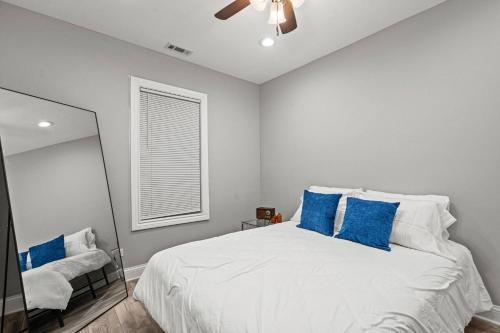 a bedroom with a white bed with blue pillows at Little India Gem - Bollywood Retreat Near Markets in Chicago