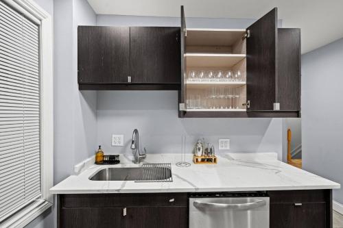 a kitchen with a sink and wooden cabinets at Little India Gem - Bollywood Retreat Near Markets in Chicago