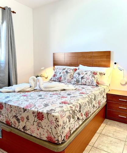 une chambre avec un grand lit avec une tête de lit en bois dans l'établissement El Oasis de Gara, à San Isidro