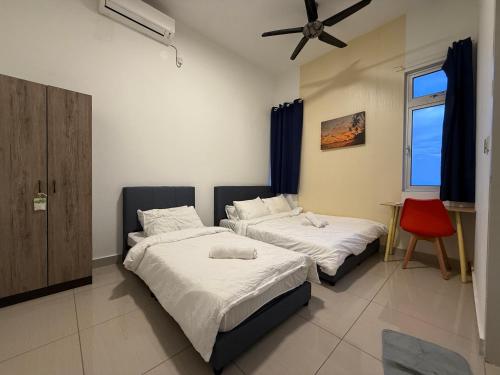 une chambre avec deux lits et une chaise rouge dans l'établissement New Cozy Comfort StayWithStyle Centra Residences at Dato ONN 3 BR 4 Bath Spacious, à Johor Bahru