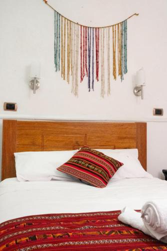 a bed with a pillow on top of it at HOTEL PALACE DIAZ inn in Cusco
