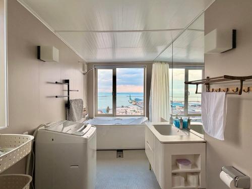 um banheiro branco com banheira e pia em 逸居&海音#200平方海景别墅#小樽步行街浪漫街附近#可以免费停放3台车#房间配有空调#暖气 em Otaru