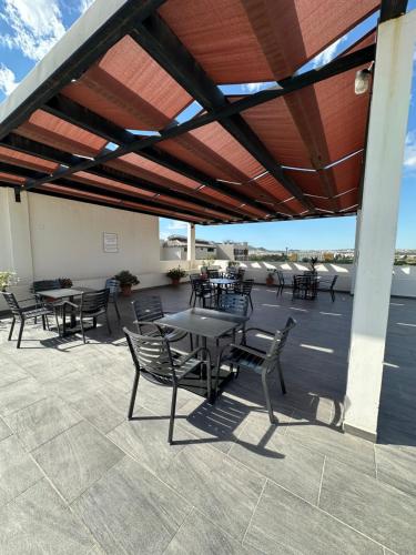 a patio with tables and chairs under a roof at Hello Sunshine! in Cabo San Lucas