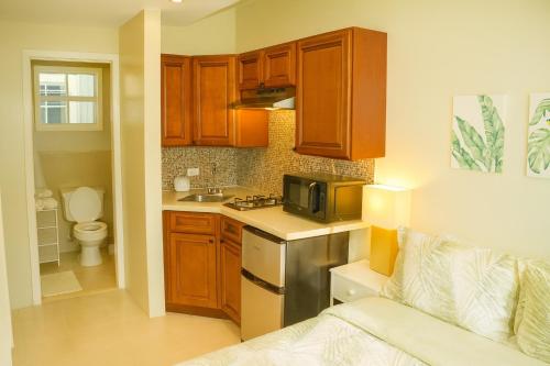 a kitchen with wooden cabinets and a sink and a microwave at Island Retreat Studio #4 in Nassau