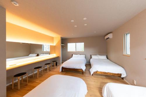 a room with three beds and stools in it at Kotohaku 木津町 in Kizugawa