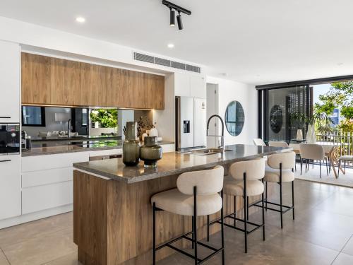 a kitchen with a large island with bar stools at Avalon Resort Maroochydore in Maroochydore