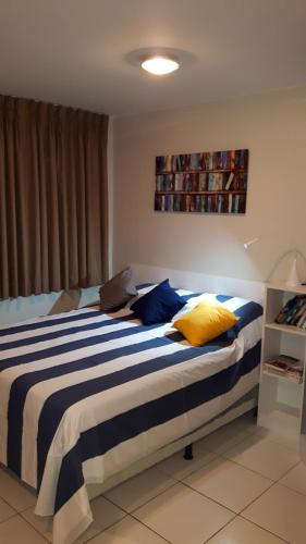 1 dormitorio con 1 cama con almohadas azules y amarillas en Villa Verde Suites Sudoeste, en Brasilia
