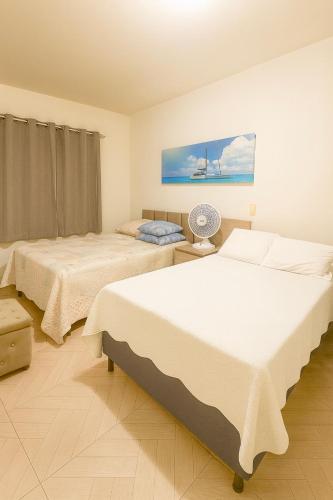 Un dormitorio con dos camas y un cuadro en la pared. en apartamento Completo Localização Excelente Centro, en Canindé