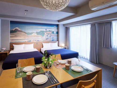 a hotel room with two beds and a dining table at Minn Ueno in Tokyo