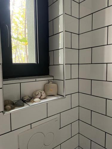 a bathroom with white tiled walls and a window at Suite de 35 m2 in Les Lilas