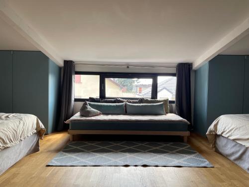 a room with two beds and a couch in front of a window at Suite de 35 m2 in Les Lilas