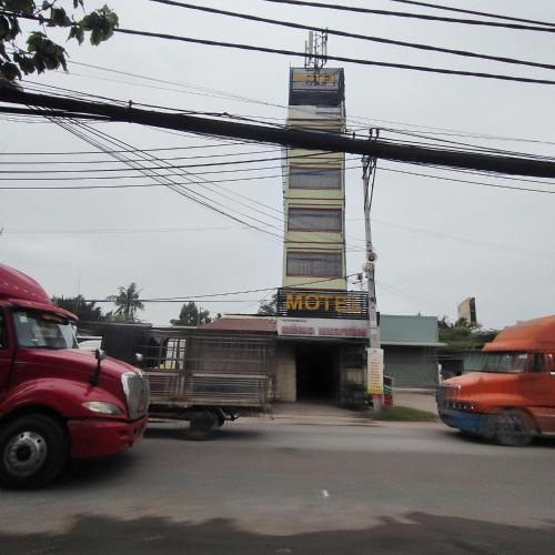 un hotel con un camión estacionado frente a él en Đồng Nguyễn Hotel, en Tân Ðiền