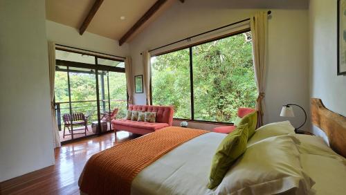 Monteverde Casa Mia, near main attractions and town! في مونتيفيردي كوستاريكا: غرفة نوم بها سرير ونافذة كبيرة