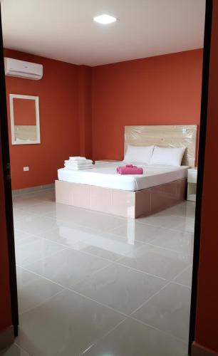 ein Schlafzimmer mit einem großen weißen Bett in einer roten Wand in der Unterkunft Apartahotel ABC in Punta Cana