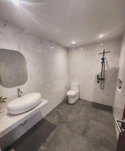 a white bathroom with a sink and a toilet at Bali Thousand Island Living in Pesanggaran