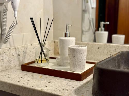 Eine Badezimmerablage mit zwei Zahnbürsten und Kerzen auf einem Tablett in der Unterkunft Vila Chalés in Mucuri