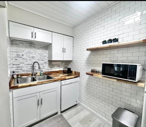 a white kitchen with a sink and a microwave at Sunlit Sands Destin Condo in Destin