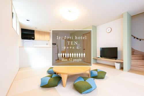 a living room with a table and a tv at Irodori Hotel TEN in Fukuoka