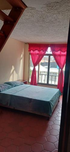 a bedroom with a bed and a window at Habitación con parqueadero in Armenia