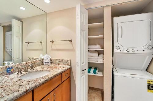 a bathroom with a sink and a washer and dryer at Mahana 307 · MA 307 OceanFront Condo w Pool AC in Kahana