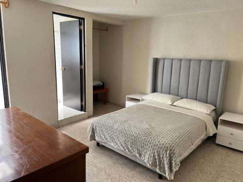 a bedroom with a large bed and a mirror at Depto de Descanso Económico vuelos AICM, conciertos GNP, F1 in Mexico City