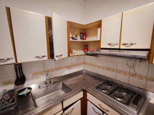 a kitchen with a sink and a stove at Kumho in Medellín