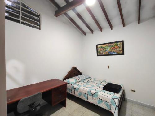 a room with a desk and a bed and a desk sidx sidx sidx at Kumho in Medellín