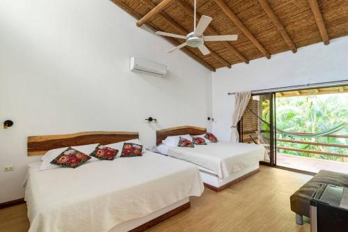 Un dormitorio con dos camas y un ventilador de techo. en Toro by Dreamcatcher, en Santa Teresa Beach