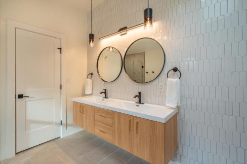 a bathroom with a sink and two mirrors on the wall at Modern Entire Home Near UVA in Charlottesville