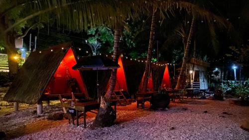 un grupo de tiendas de campaña en una playa por la noche en Alfonsa Tent Ground - Camp By The Sea, en Oslob