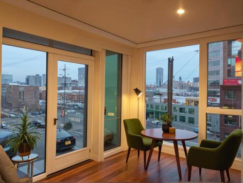 a room with a table and chairs and windows at Glamorous KTown Boutique Residences with Rooftop view in Los Angeles