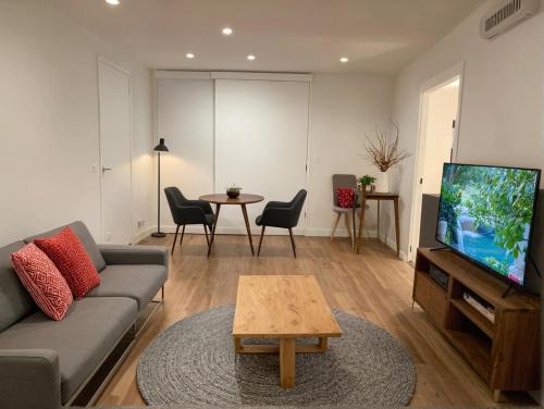 a living room with a couch and a tv and a table at Glamorous KTown Boutique Residences with Rooftop view in Los Angeles