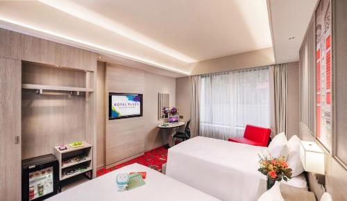 Una habitación de hotel con una cama y un televisor. en Royal Plaza on Scotts, en Singapur