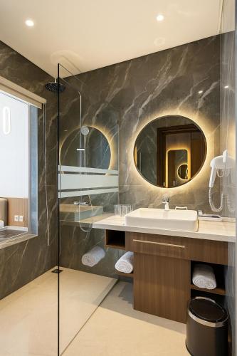 a bathroom with a sink and a mirror at Ijen Suites Resort & Convention in Malang