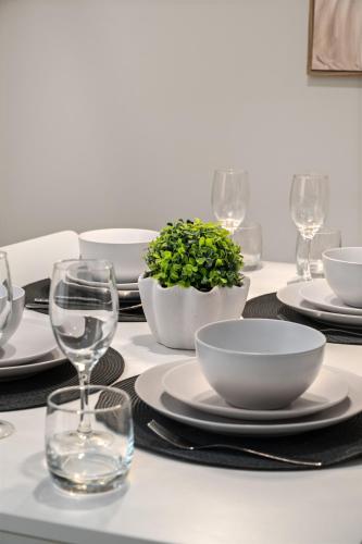 a table with plates and bowls and glasses on it at Smart Suites Self Check-in Apartments - Sunnybank Station in Brisbane