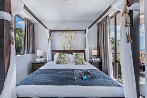 a bedroom with a canopy bed with a stuffed animal on it at Ocean View Apartment 49 in Airlie Beach