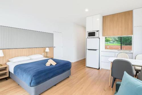a bedroom with a bed and a table and a kitchen at Apollo Dream Suites in Apollo Bay