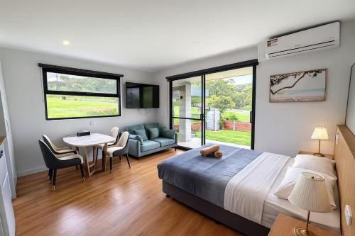 Un dormitorio con una cama y una mesa y sillas. en Apollo Dream Suites, en Apollo Bay