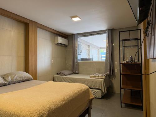 a hotel room with two beds and a window at Moradas Desterro, próximo ao aeroporto 01 in Florianópolis