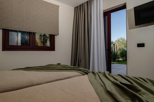 a bedroom with a bed and a sliding glass door at Adelda Villa in Kypseli