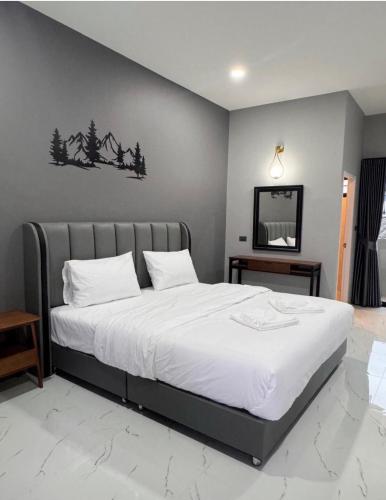 a bedroom with a large bed with white sheets at The Breezy Hotel in Muak Lek District