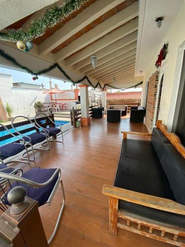 AhuatepecにあるCasa Isabella in Cuernavacaの椅子とソファとプールのあるリビングルーム