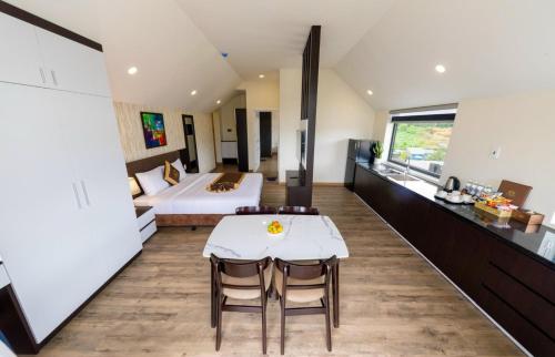 ein Schlafzimmer mit einem Bett, einem Tisch und Stühlen in der Unterkunft ROYAL DRAGON HOTEL in Da Lat