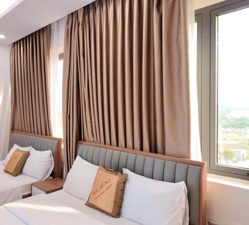 a hotel room with two beds and a window at Hà Hùng Panorama Hotel in Ha Tien
