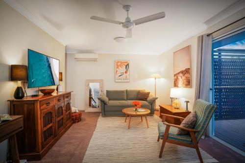a living room with a couch and a tv at Milton Village Retreat - secluded comfort in Milton