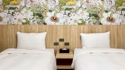a bedroom with two beds and a floral wallpaper at 星雨行館-逢甲洲際館 in Taichung