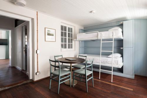 a room with a bunk bed and a table and chairs at Garde and Warders Hotel in Fremantle