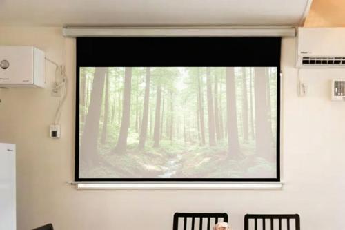 a projection screen in a room with a forest at 和光荘 Harmonious Light West in Hakone