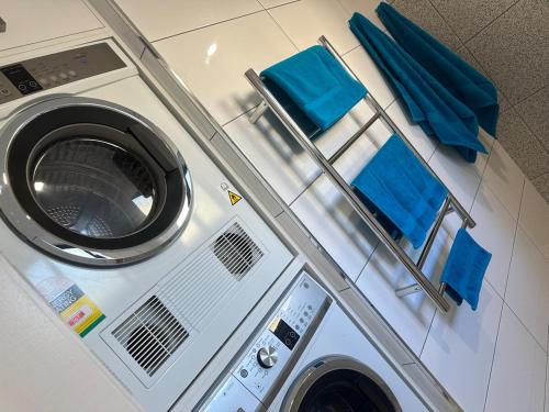 una lavanderia con lavatrice e asciugamani blu di Cosy on Colless a Mulwala